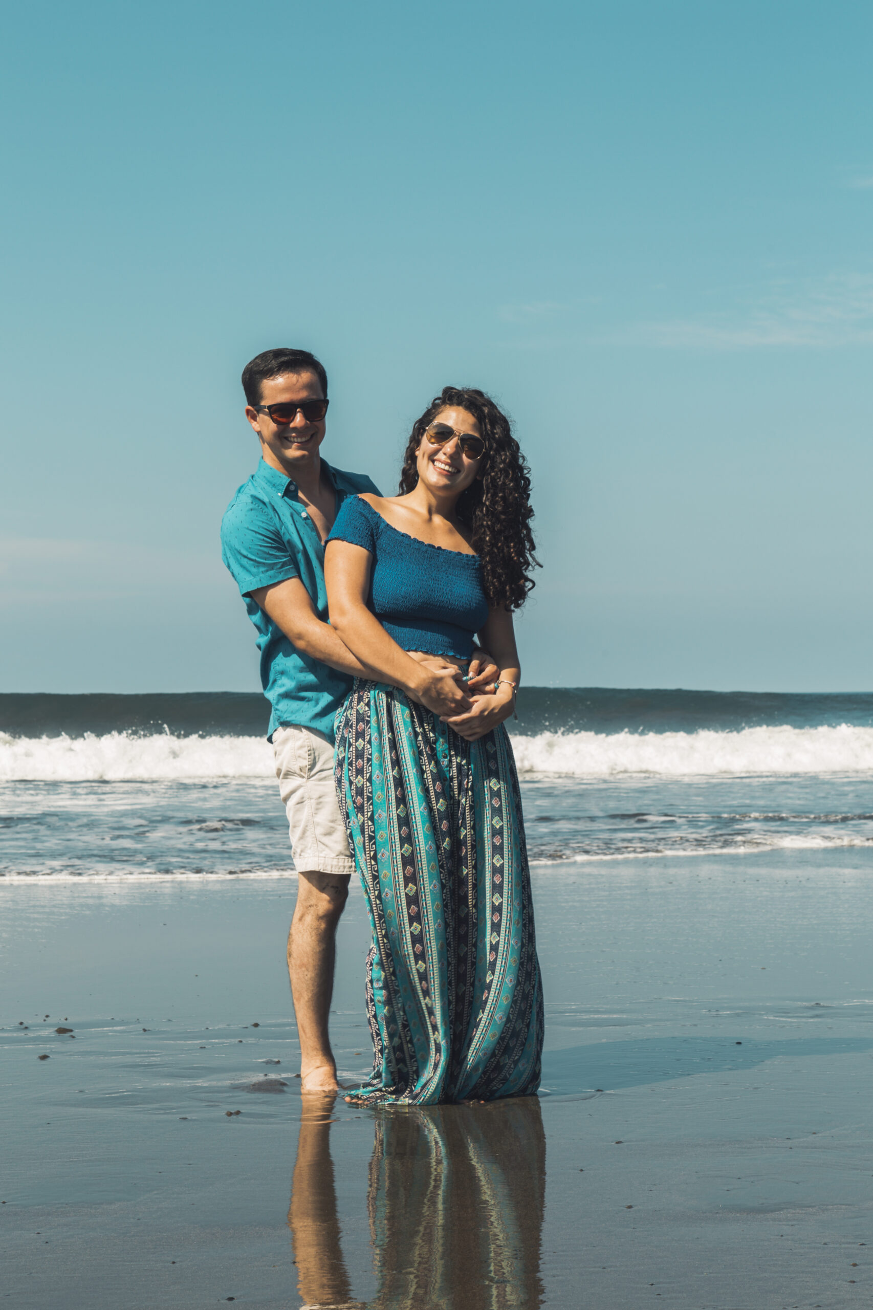 smiling-man-woman-hugging-waterfront-beach