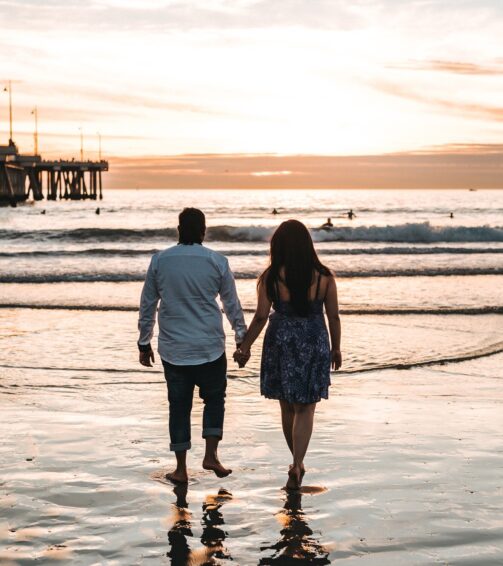 couple-holding-hands-with-each-other-while-walking-seashore-daytime_181624-29353