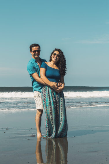 smiling-man-woman-hugging-waterfront-beach